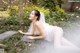 A woman in a wedding dress laying on the ground.