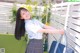 A young woman in a school uniform holding a blue bag.