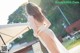 A woman in a white dress standing on a wooden deck.