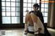 A woman sitting on the floor in front of a window.