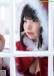 A woman in a santa claus outfit looking out of a window.